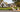 European house plan floor plan with 4 bedrooms, 3-car garage, open great room, kitchen and dining area, covered rear porch, and upstairs bonus room with balcony.